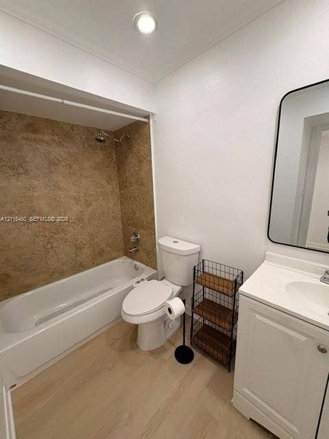 9301 SW 92nd Avenue, #A418, Miami, Miami, FL 33176 Bathroom featuring a white vanity cabinet with an integrated sink, wall-mounted rectangular mirror with a black frame, wood-finish flooring, and a bathtub surround with textured tile detailing