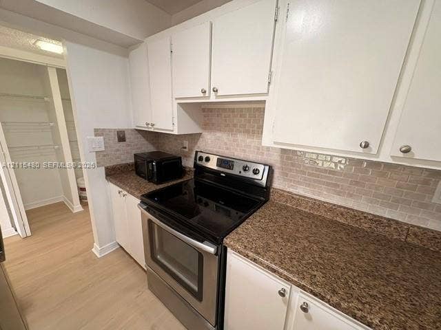9301 SW 92nd Avenue, #A418, Miami, Miami, FL 33176 Kitchen featuring white cabinetry, stone-finish countertops, subway tile backsplash, stainless steel electric range, and an integrated pantry with wire shelving