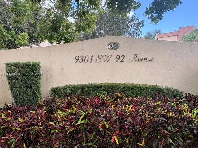 9301 SW 92nd Avenue, #A418, Miami, Miami, FL 33176 Stucco monument signage featuring dimensional house numbers and an oval architectural accent, surrounded by manicured shrubs and ornamental foliage