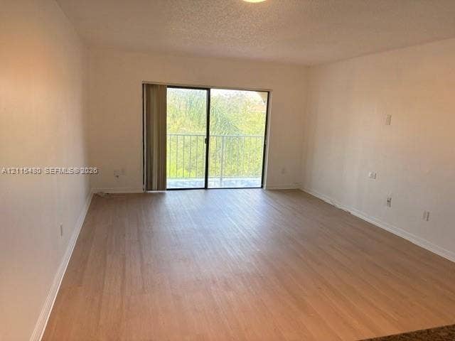 9301 SW 92nd Avenue, #A418, Miami, Miami, FL 33176 Neutral interior featuring wood-finish flooring, sliding glass door, and metal balcony railing