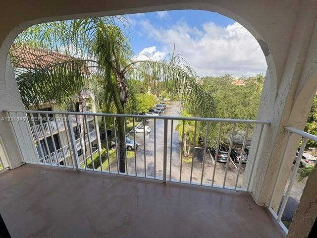 9301 SW 92nd Avenue, #A418, Miami, Miami, FL 33176 Covered balcony featuring an arched entryway, smooth-finish concrete flooring, and a white metal railing