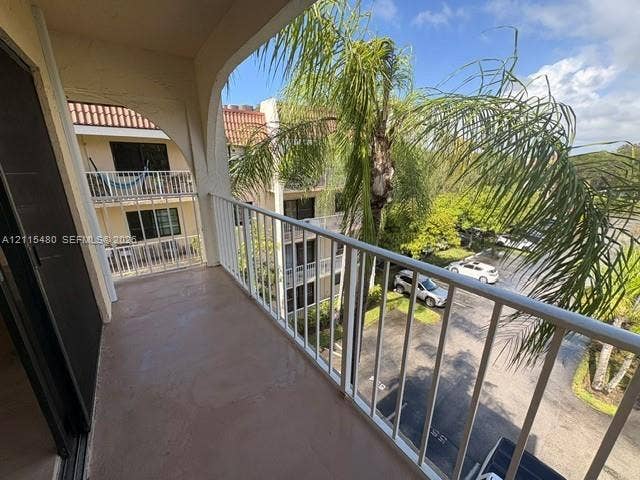 9301 SW 92nd Avenue, #A418, Miami, Miami, FL 33176 Covered balcony with a concrete floor, arched architectural detailing, and white metal railing