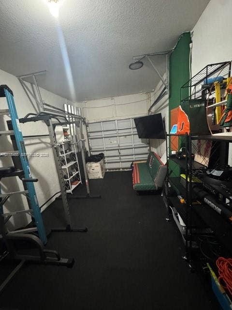 14973 SW 9th Terrace, Miami, Miami, FL 33194 Garage space featuring a metal sectional door and solid flooring