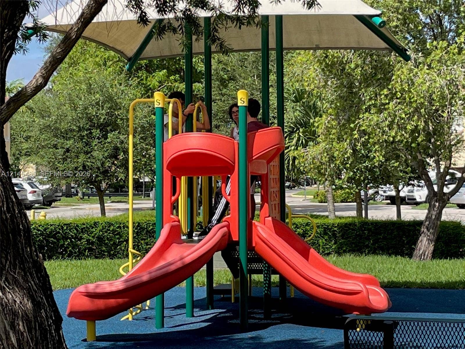14973 SW 9th Terrace, Miami, Miami, FL 33194 Outdoor recreation area featuring a playground structure with twin slides, a canopy cover, and a rubberized play surface