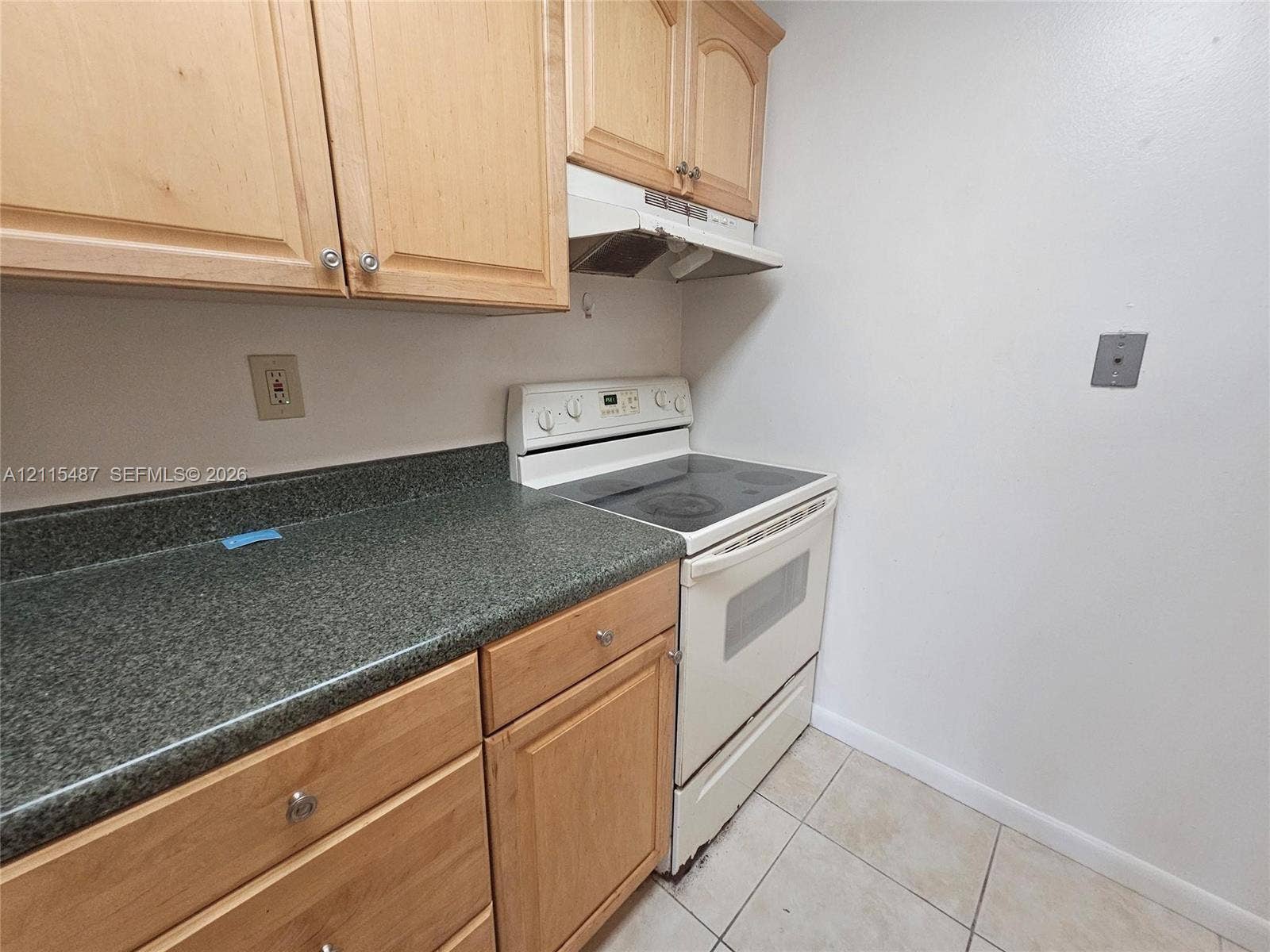 4279 NW 89th Avenue, #205, Coral Springs, Coral Springs, FL 33065 Kitchen featuring light wood-finish cabinetry, solid-surface countertops, built-in range, range hood, and tile flooring