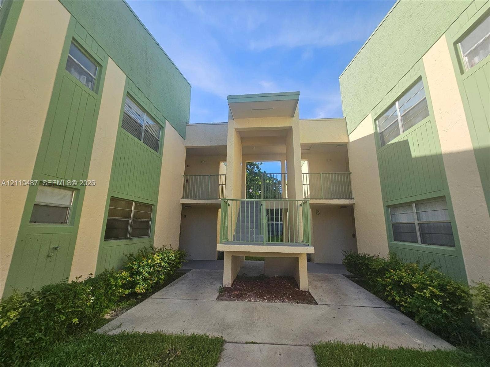 4279 NW 89th Avenue, #205, Coral Springs, Coral Springs, FL 33065 Two-story exterior featuring a stucco and vertical siding facade, metal railings, recessed entrances, and concrete walkways