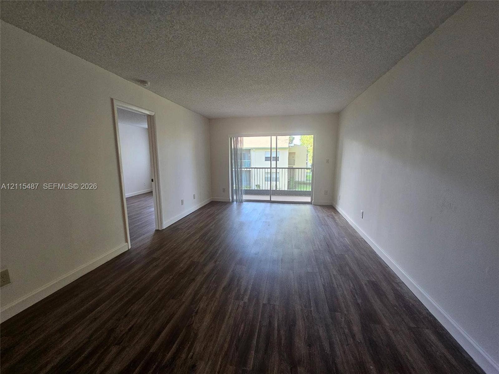 4279 NW 89th Avenue, #205, Coral Springs, Coral Springs, FL 33065 Open floor plan featuring wood-finish flooring, sliding glass doors, and a private balcony