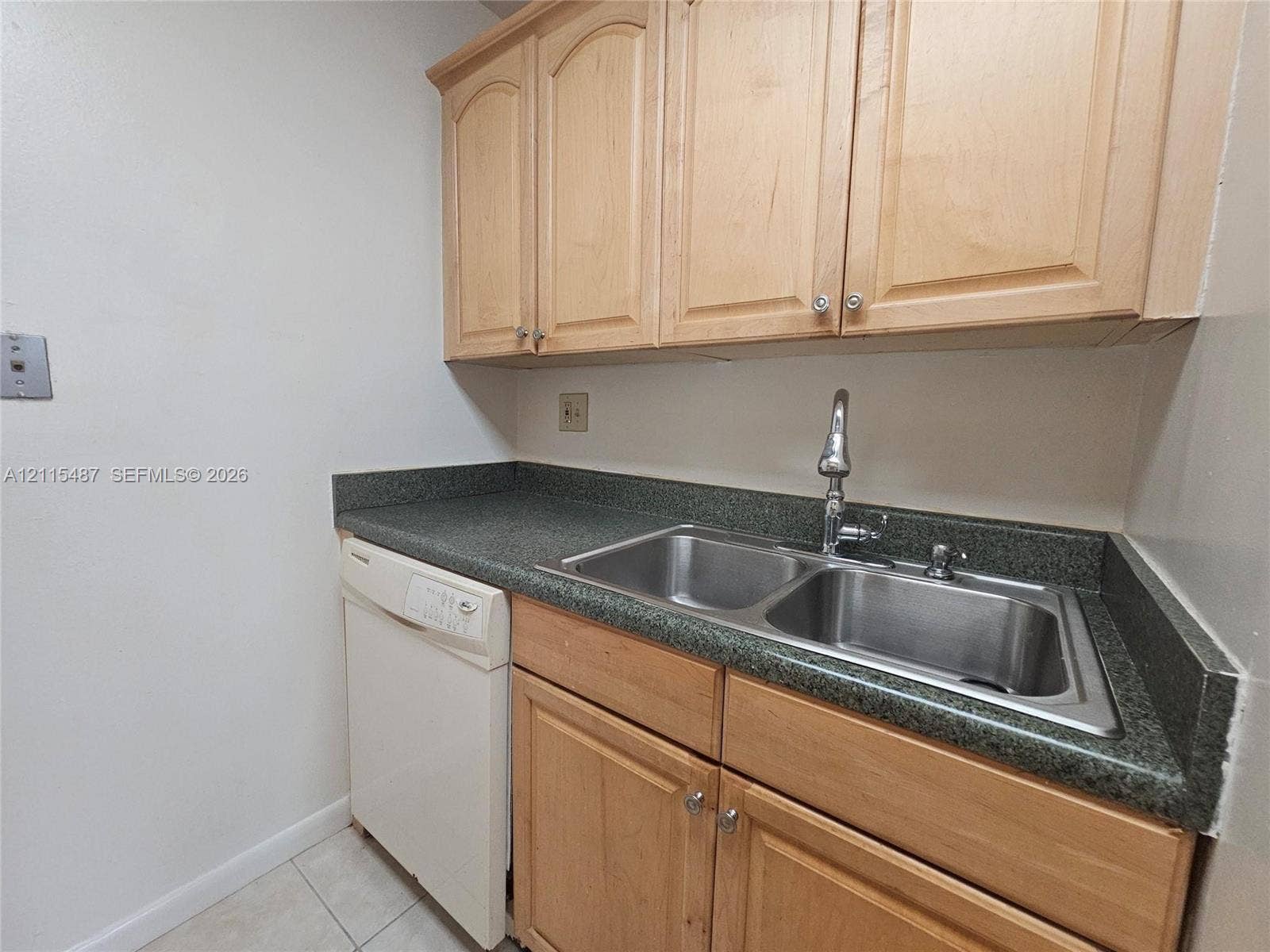 4279 NW 89th Avenue, #205, Coral Springs, Coral Springs, FL 33065 Light-wood cabinetry, dark stone-finish countertops, dual-basin stainless steel sink with high-arc faucet, and integrated dishwasher