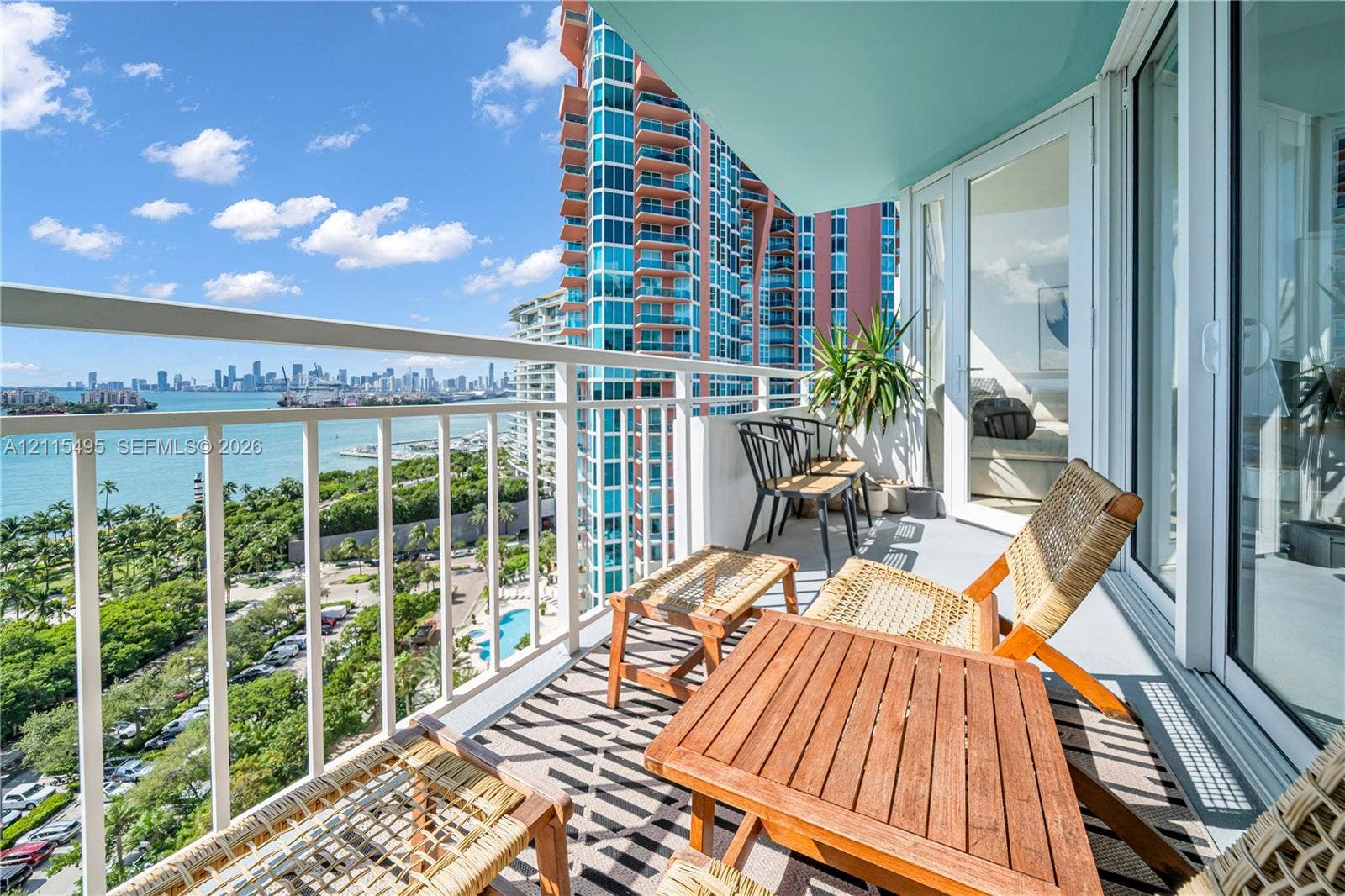Private balcony featuring white metal railings, concrete flooring, and sliding glass door access