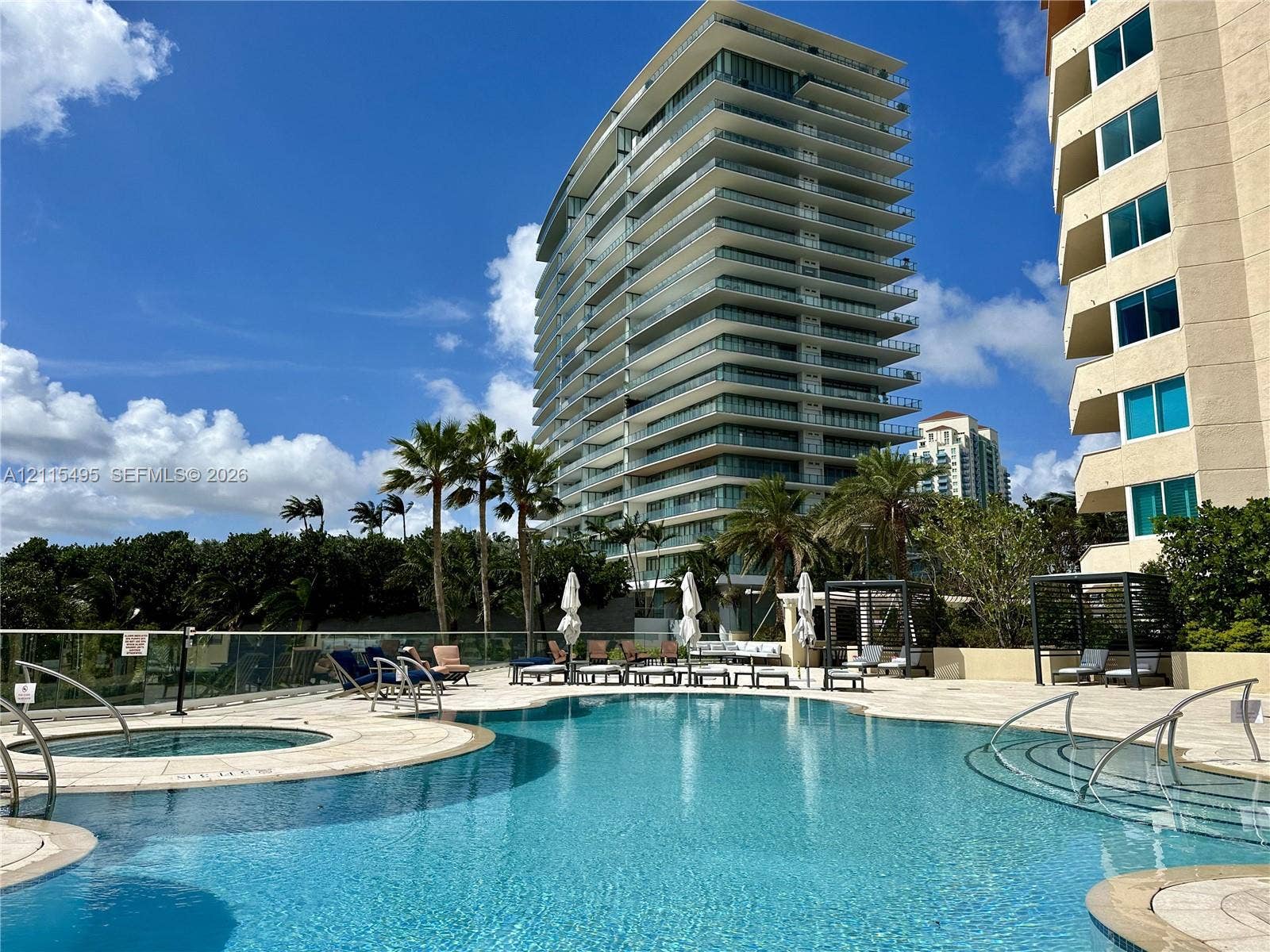 Swimming pool with integrated spa, paved pool deck, and shaded cabanas