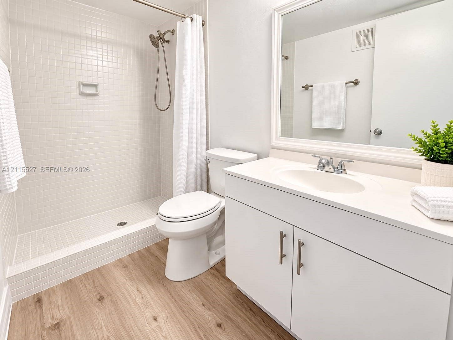 220 Lakeview Drive, #101, Weston, Weston, FL 33326 Bathroom featuring a white vanity with an integrated basin, wood-finish flooring, and a walk-in shower with white tile surround