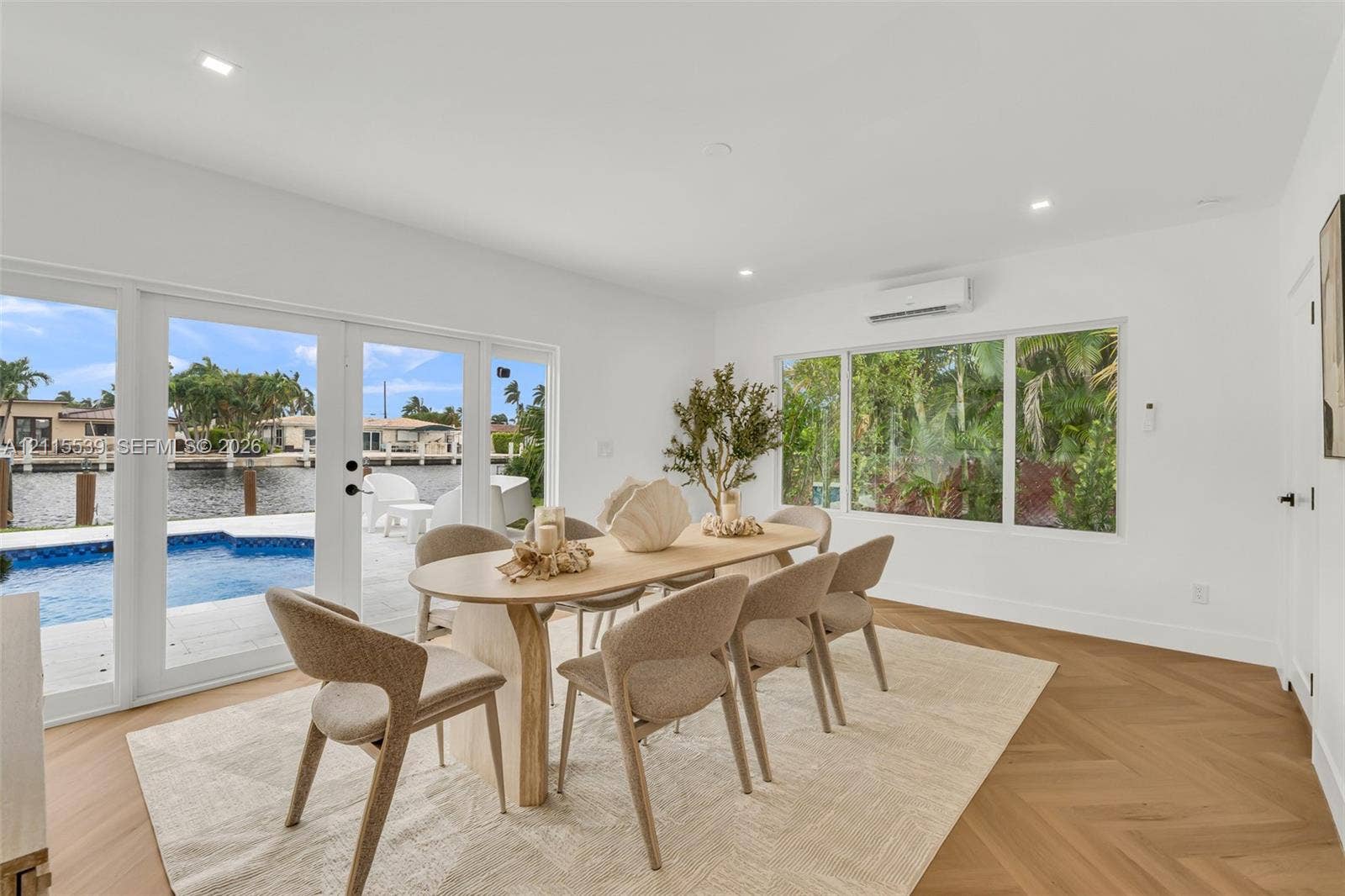 381 SE 6th Terrace, Pompano Beach, FL 33060 Interior space featuring herringbone-pattern wood-finish flooring, recessed lighting, and wall-mounted ductless air conditioning