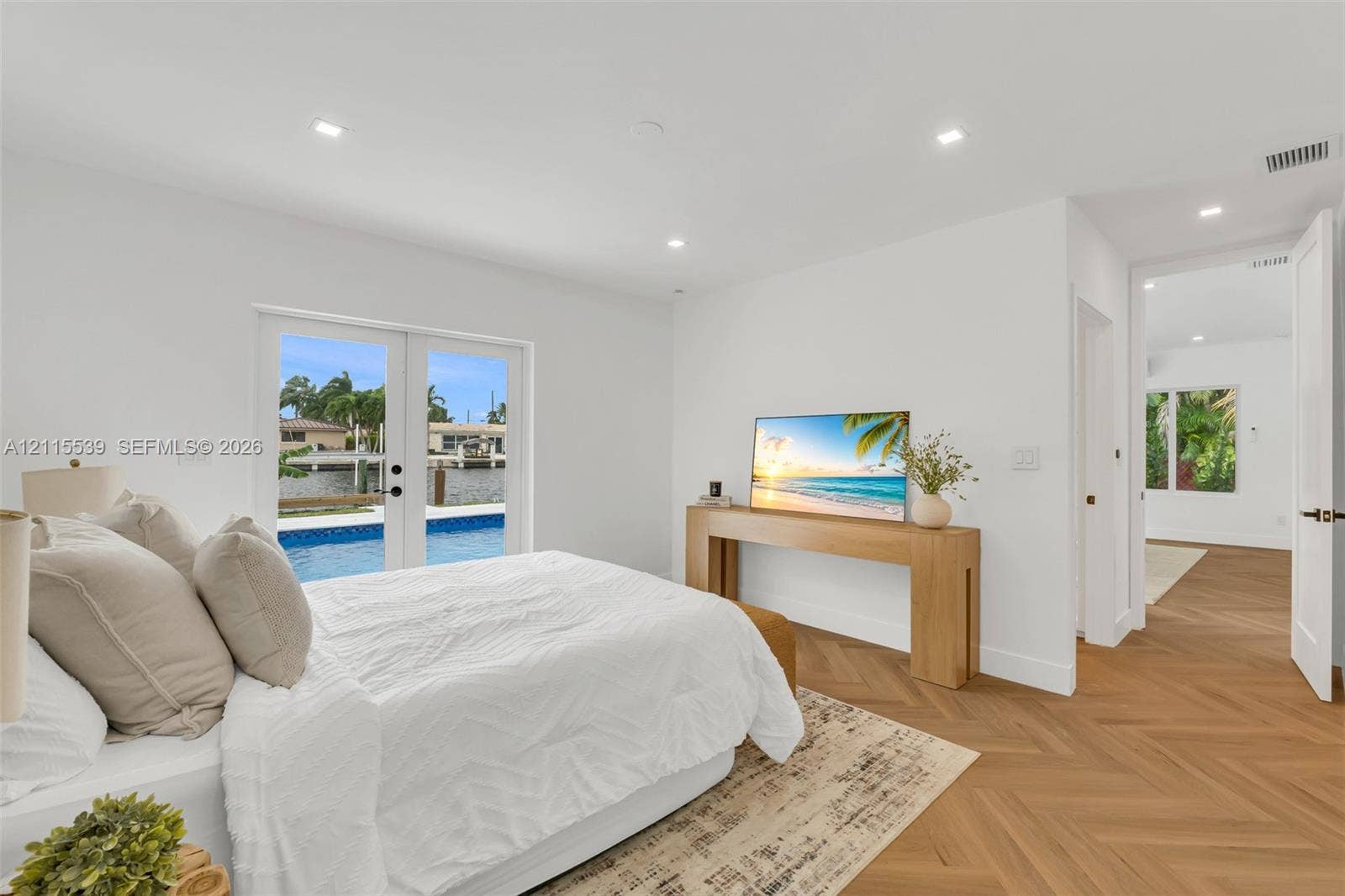 381 SE 6th Terrace, Pompano Beach, FL 33060 Herringbone-patterned wood-finish flooring, recessed lighting, and double glass-paned doors opening to an outdoor pool area