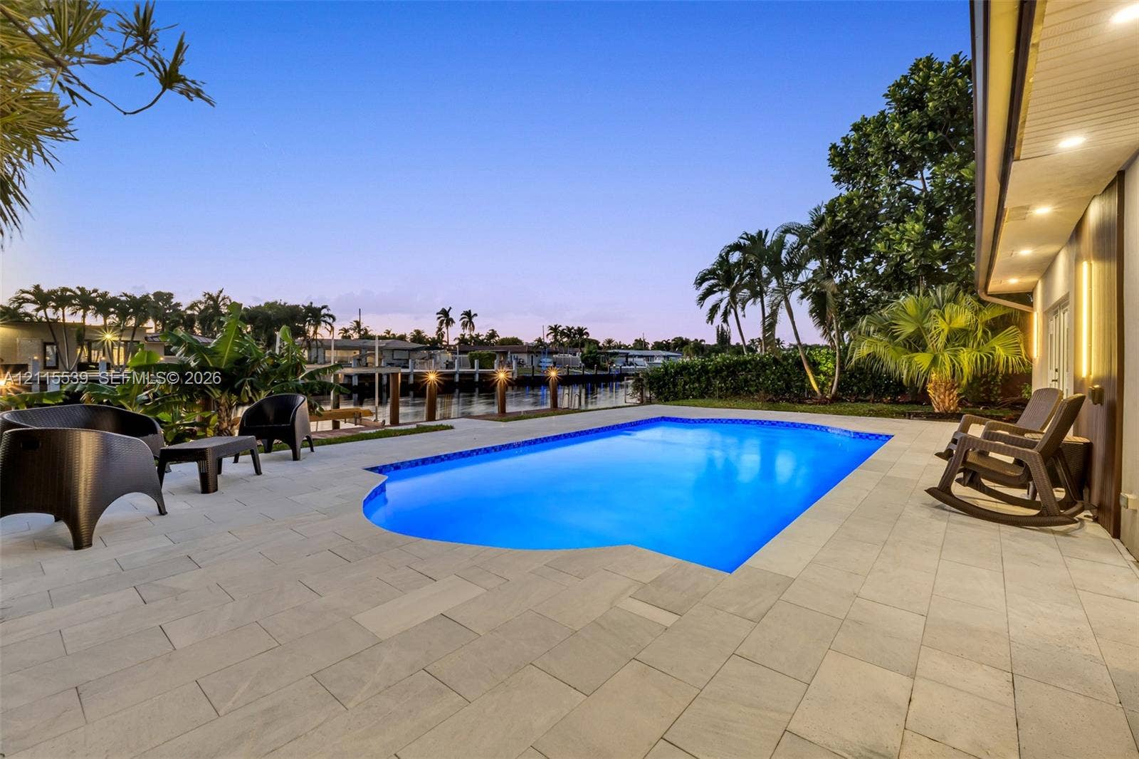 381 SE 6th Terrace, Pompano Beach, FL 33060 In-ground pool featuring a stone-paver deck, waterfront bulkhead, and integrated recessed lighting