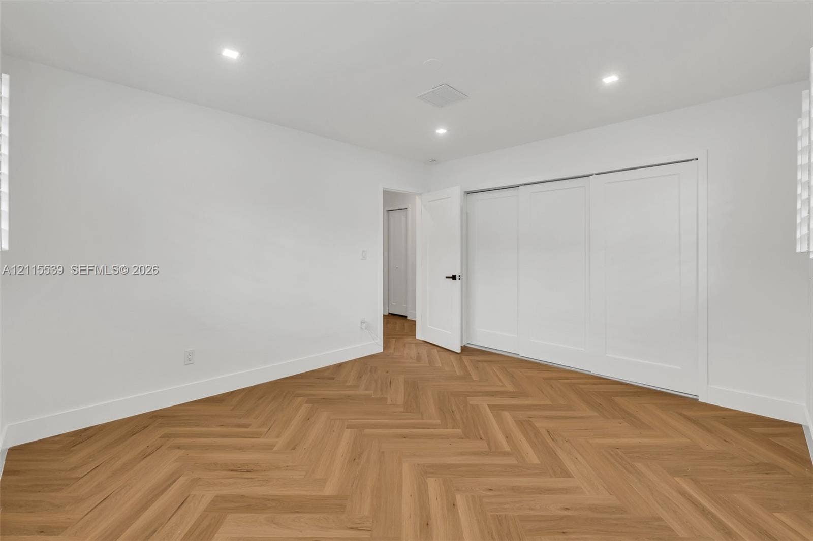 381 SE 6th Terrace, Pompano Beach, FL 33060 Herringbone wood-finish flooring, recessed lighting, and three-panel sliding closet doors with matte black hardware