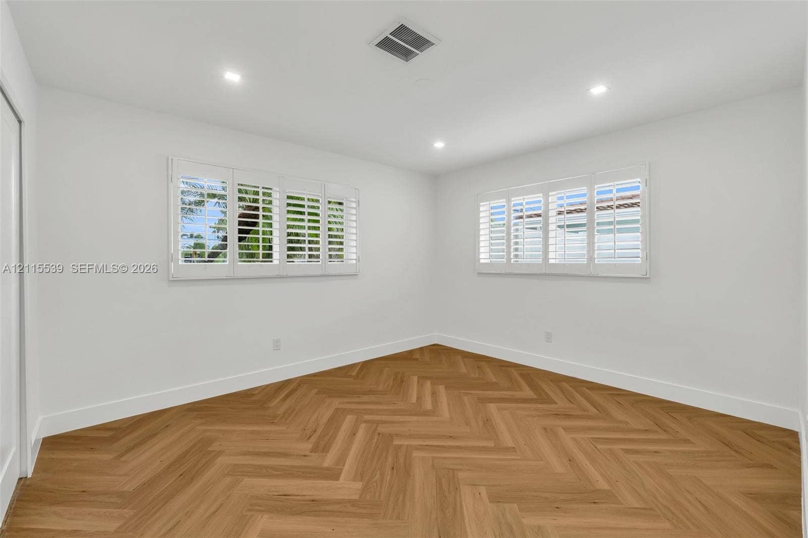 381 SE 6th Terrace, Pompano Beach, FL 33060 Interior room featuring wood-finish herringbone flooring, recessed lighting, and white plantation shutters