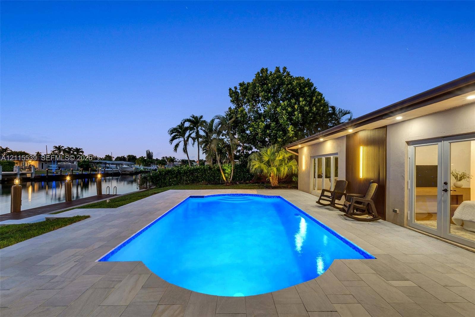 381 SE 6th Terrace, Pompano Beach, FL 33060 In-ground swimming pool with stone-tiled patio, waterfront bulkhead, and private boat dock