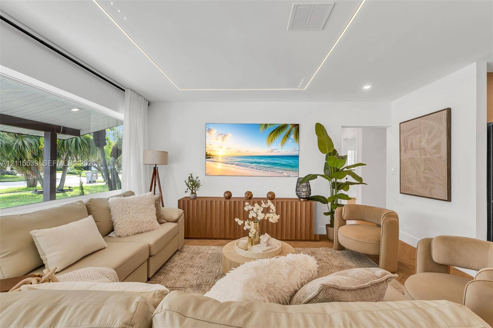 381 SE 6th Terrace, Pompano Beach, FL 33060 Living area featuring expansive floor-to-ceiling windows, recessed perimeter tray ceiling lighting, and herringbone-pattern wood-finish flooring