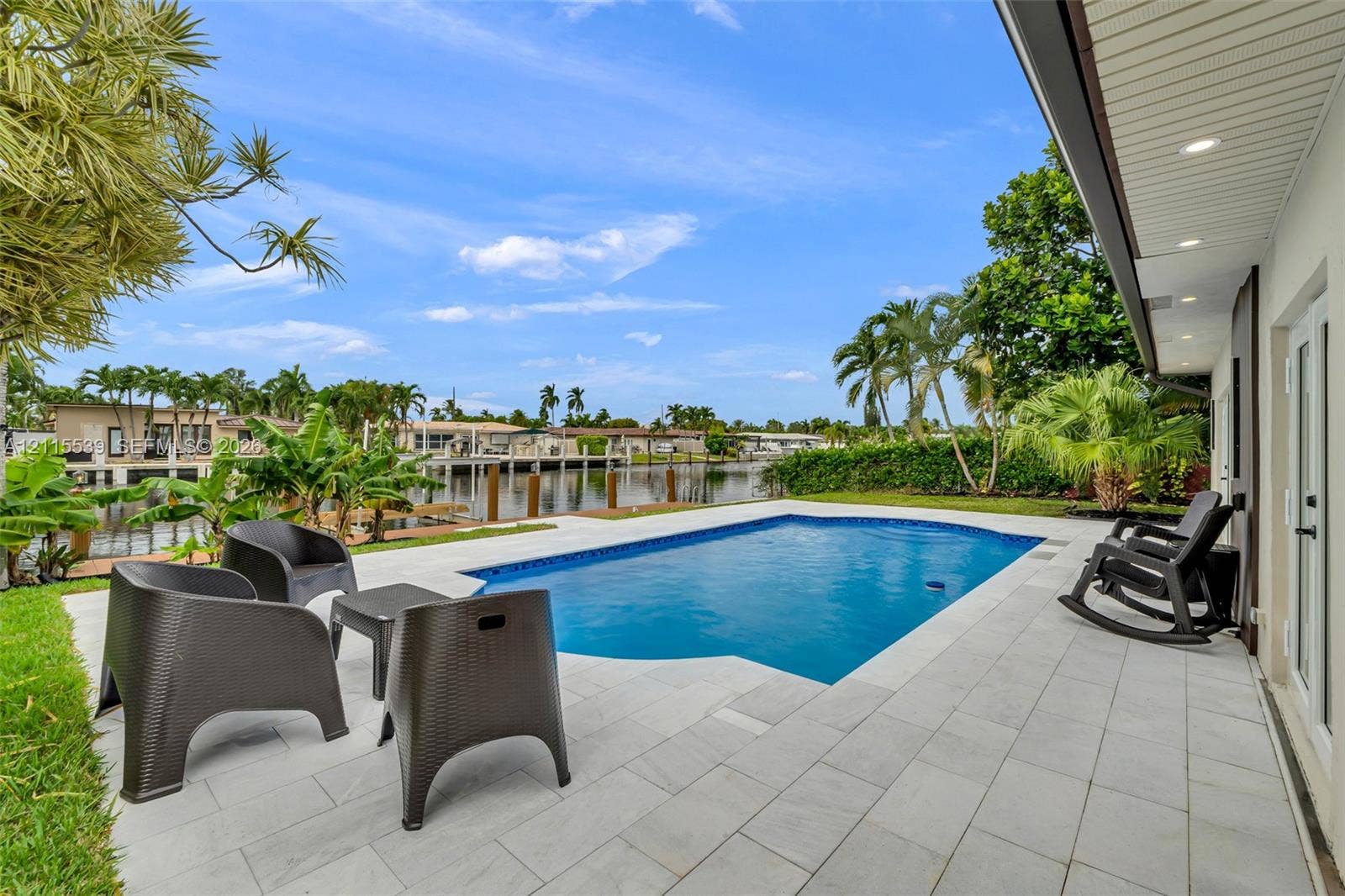 381 SE 6th Terrace, Pompano Beach, FL 33060 Waterfront swimming pool with a stone paver deck and a recessed soffit featuring integrated lighting