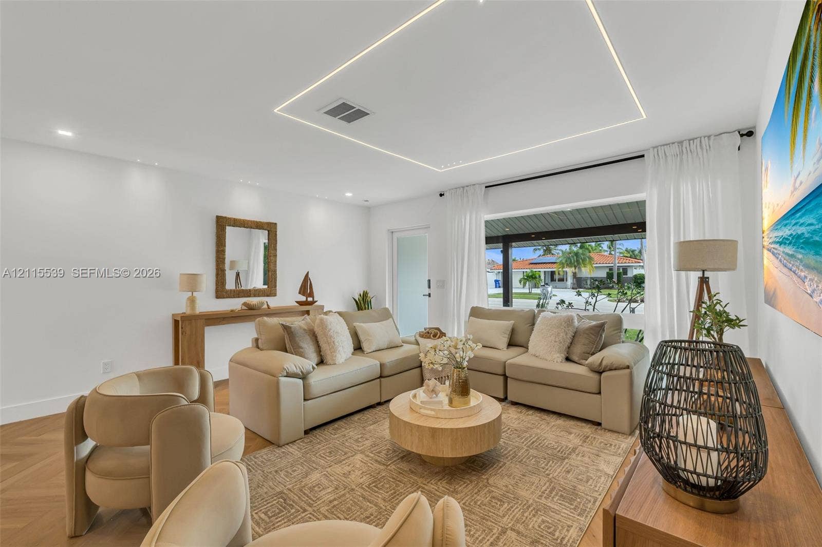 381 SE 6th Terrace, Pompano Beach, FL 33060 Living space featuring herringbone-pattern wood-finish flooring, recessed LED cove lighting, and floor-to-ceiling windows