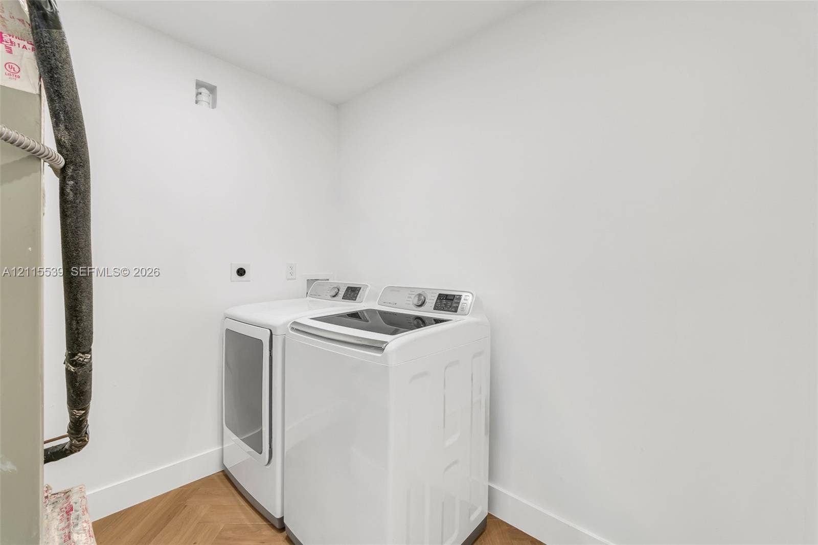 381 SE 6th Terrace, Pompano Beach, FL 33060 Laundry area featuring wood-finish herringbone flooring and white walls