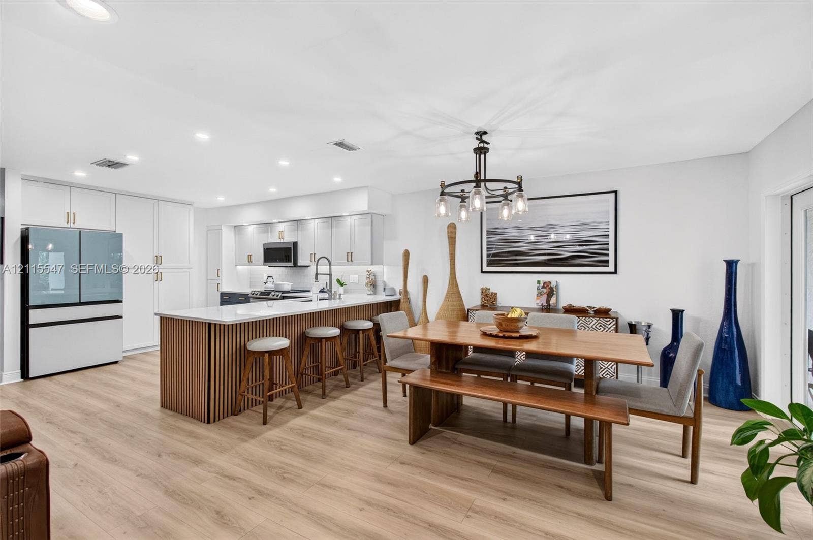 22862 Ironwedge Drive, #0, Boca Raton, FL 33433 Kitchen featuring white shaker-style cabinetry, wood-slat kitchen island with a white countertop, recessed lighting, chandelier, and wood-finish flooring