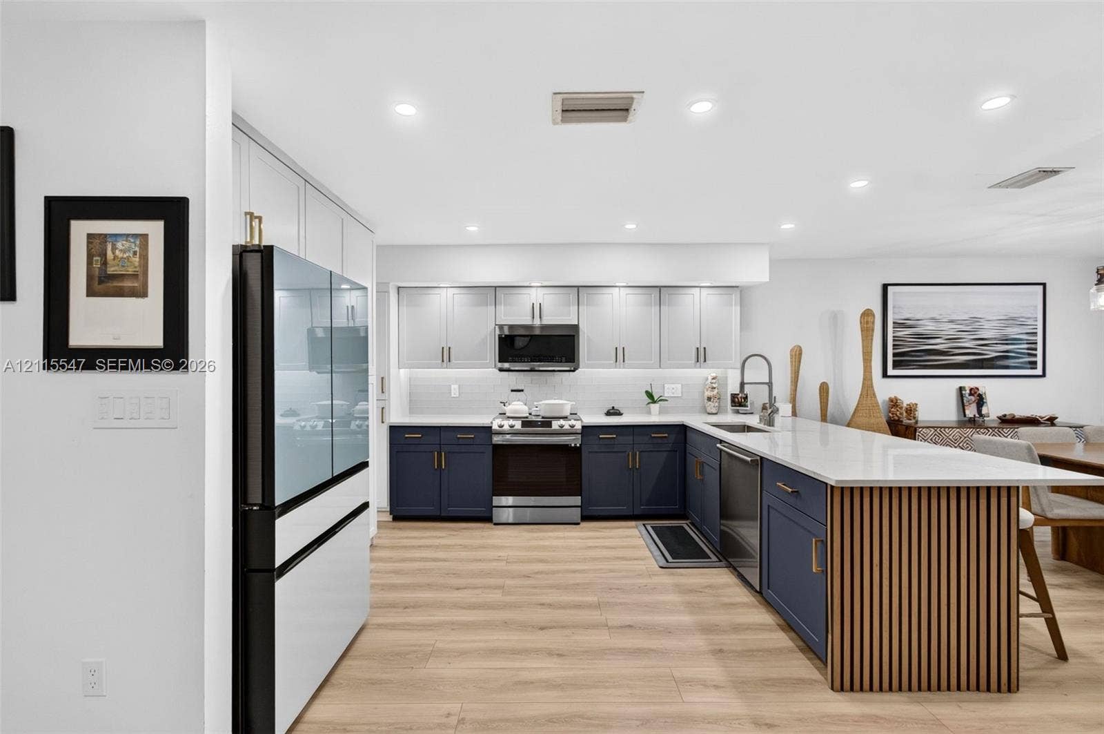 22862 Ironwedge Drive, #0, Boca Raton, FL 33433 Kitchen featuring two-tone cabinetry, wood-finish flooring, recessed lighting, stone countertops, and a wood-slat kitchen island facade