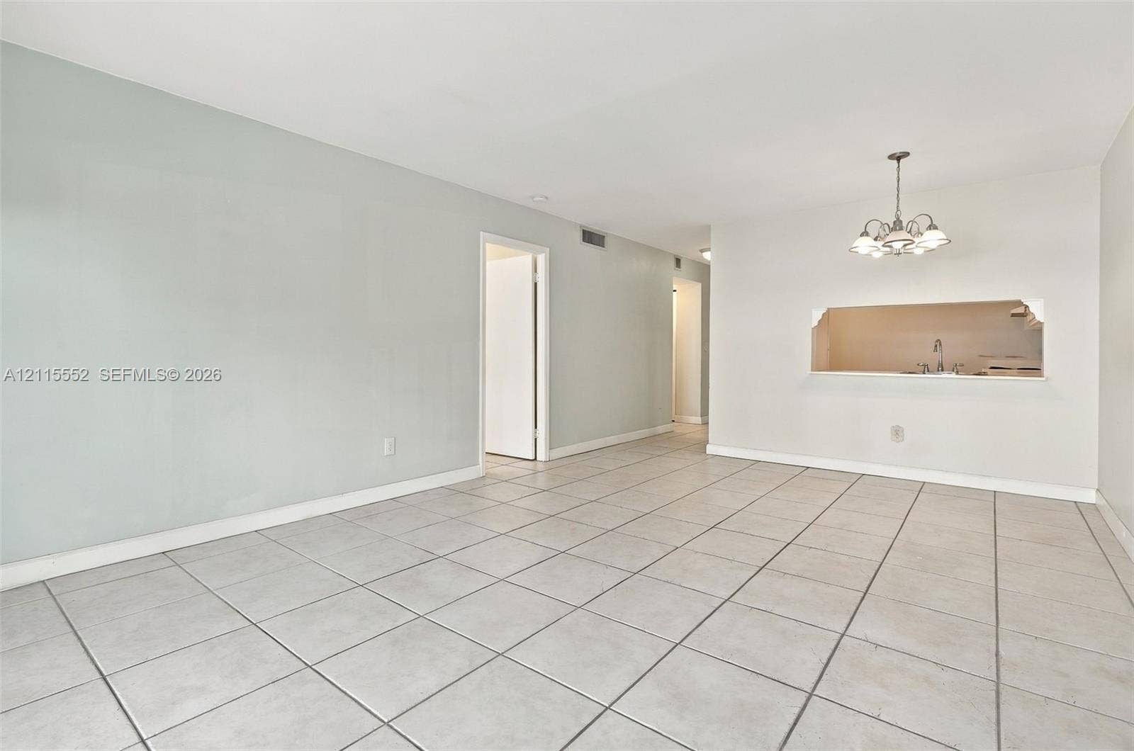 7805 Camino Real, #H-220, Miami, FL 33143 Ceramic tile flooring, neutral wall tones, multi-arm chandelier, and a cut-out wall opening
