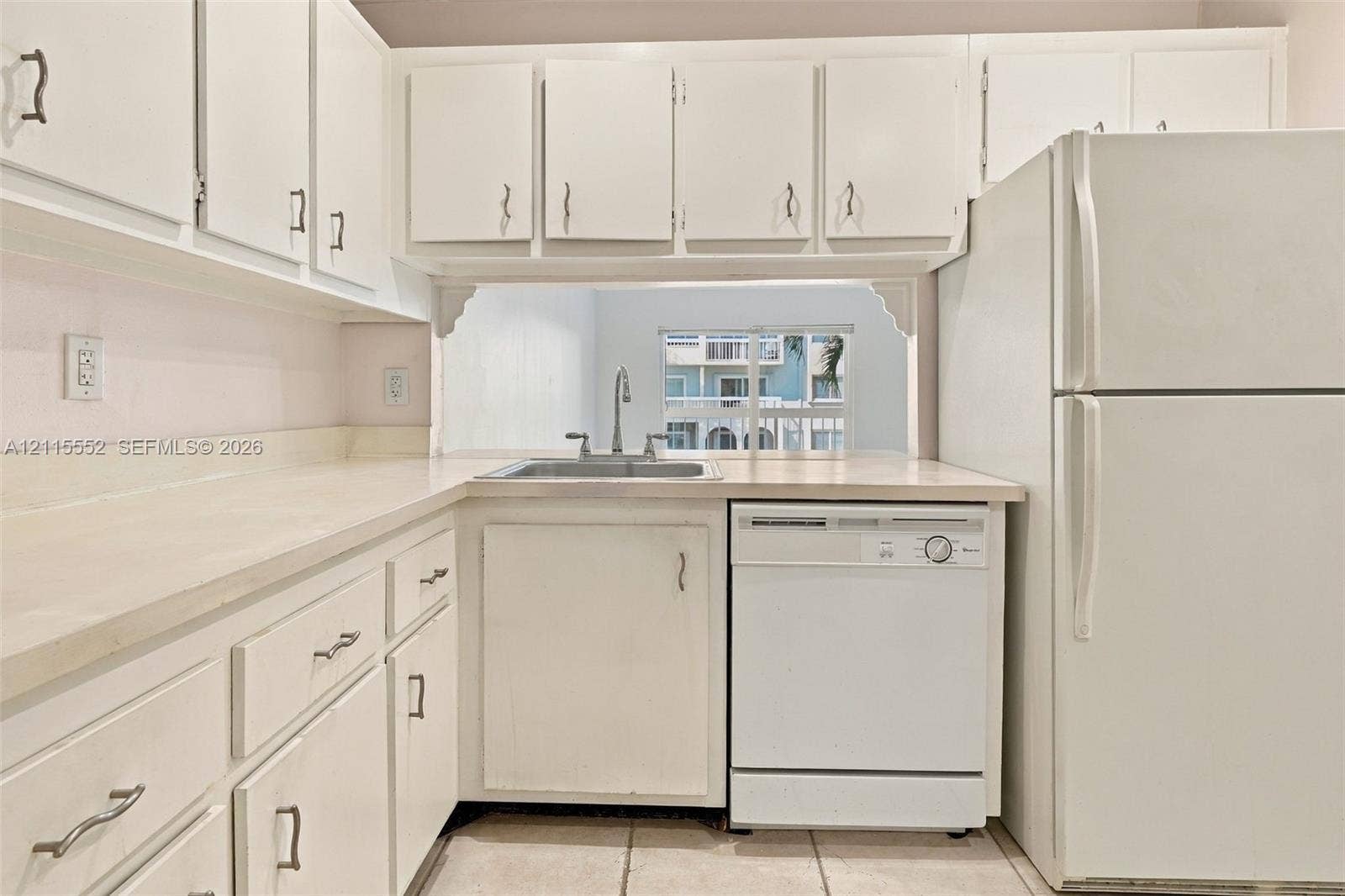 7805 Camino Real, #H-220, Miami, FL 33143 Kitchen featuring white cabinetry with brushed metal hardware, solid-surface countertops, a stainless steel sink with a goose-neck faucet, a built-in dishwasher, and a top-freezer refrigerator