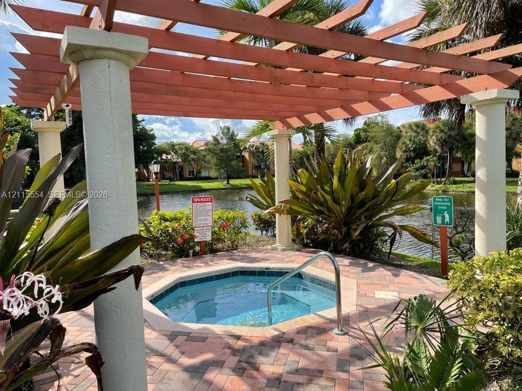 10781 Cleary Boulevard, #210, Plantation, Plantation, FL 33324 Octagonal spa featuring a brick-paver deck, pergola structure with concrete columns, and integrated stainless steel handrail