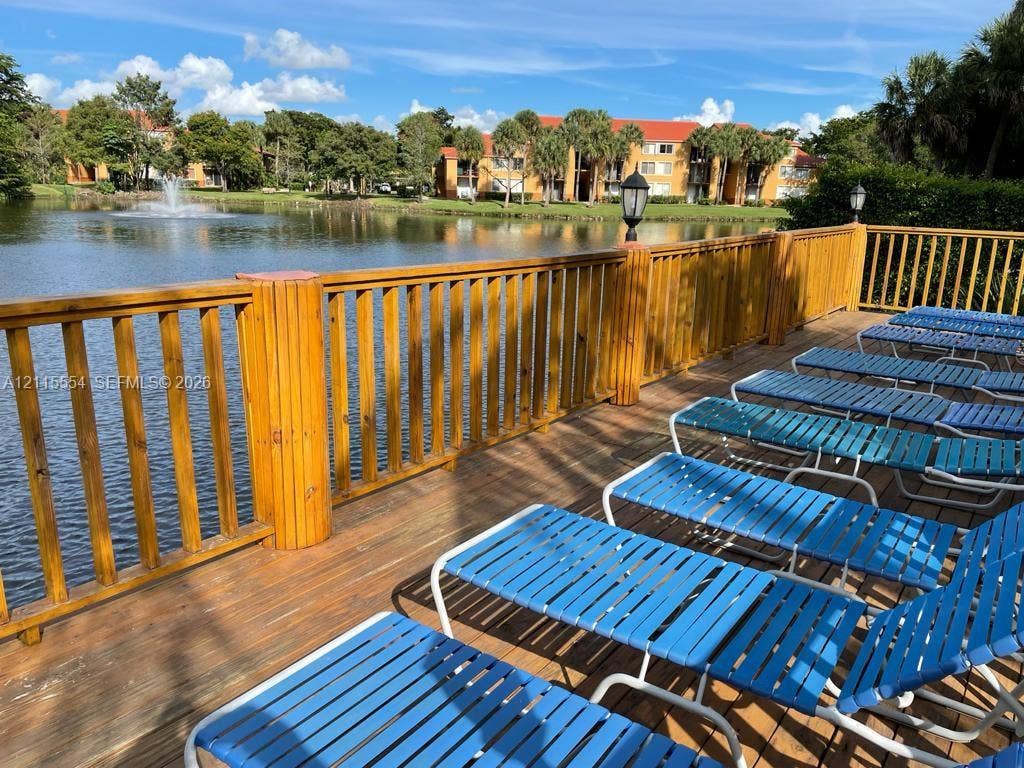 10781 Cleary Boulevard, #210, Plantation, Plantation, FL 33324 Wood-plank deck featuring a wooden balustrade, integrated post-mounted lighting, and a water feature