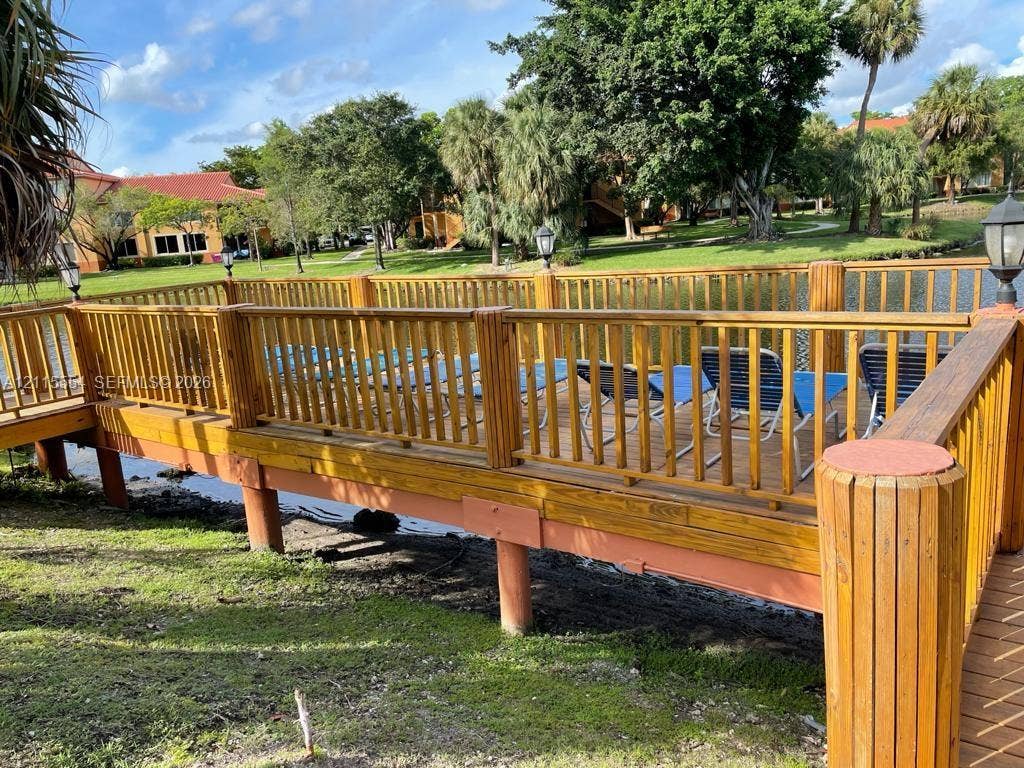 10781 Cleary Boulevard, #210, Plantation, Plantation, FL 33324 Wood-finished deck featuring perimeter railings, post-mounted exterior lighting, and water-front placement