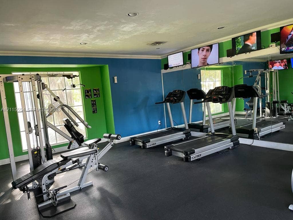 10781 Cleary Boulevard, #210, Plantation, Plantation, FL 33324 Fitness area featuring recessed lighting, a full-length wall mirror, grid-pane windows, and high-impact rubber flooring