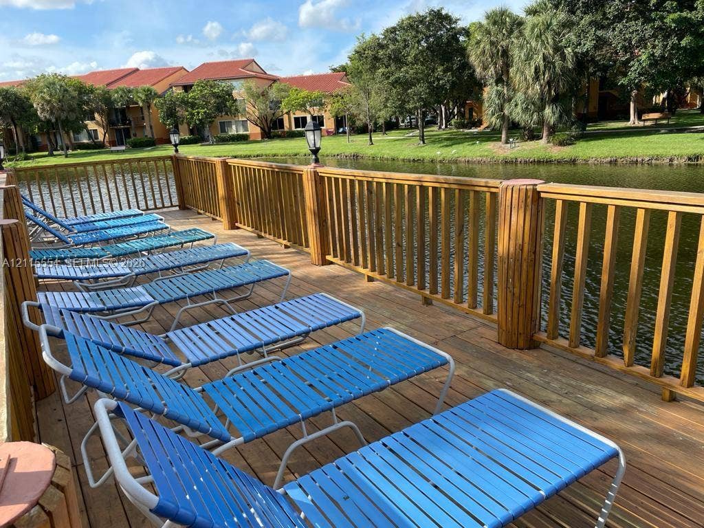 10781 Cleary Boulevard, #210, Plantation, Plantation, FL 33324 Waterfront wooden deck featuring built-in vertical post lighting and a perimeter railing
