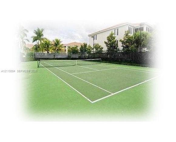 10781 Cleary Boulevard, #210, Plantation, Plantation, FL 33324 Tennis court featuring a hard surface, perimeter fencing, and surrounding mature landscaping