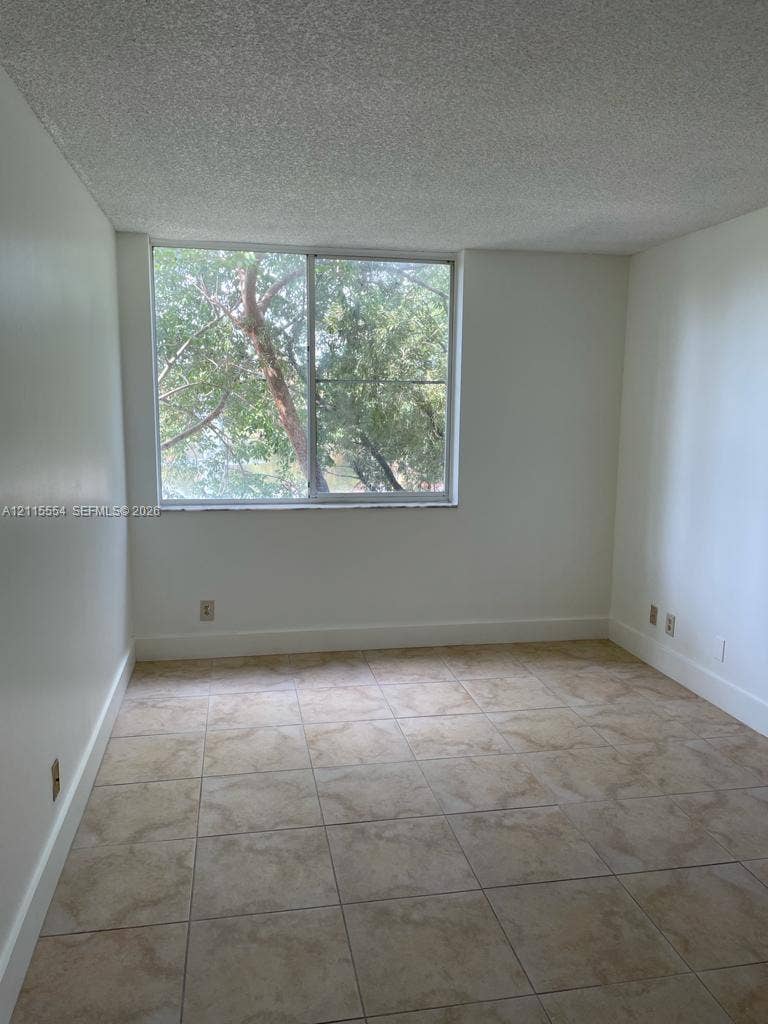 10781 Cleary Boulevard, #210, Plantation, Plantation, FL 33324 Interior space featuring large-format ceramic tile flooring, neutral wall finishes, and a single sliding window