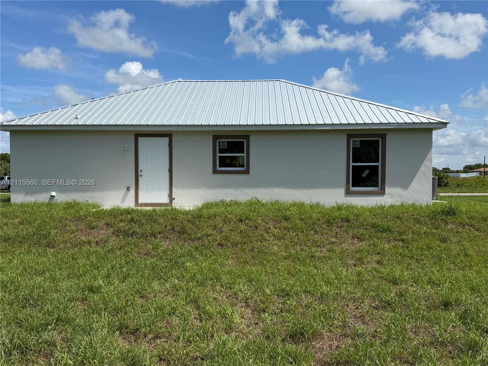 105 Concord Loop, Labelle, FL 33935 Stucco exterior featuring a metal roof, clean-lined trim, and dual pane windows