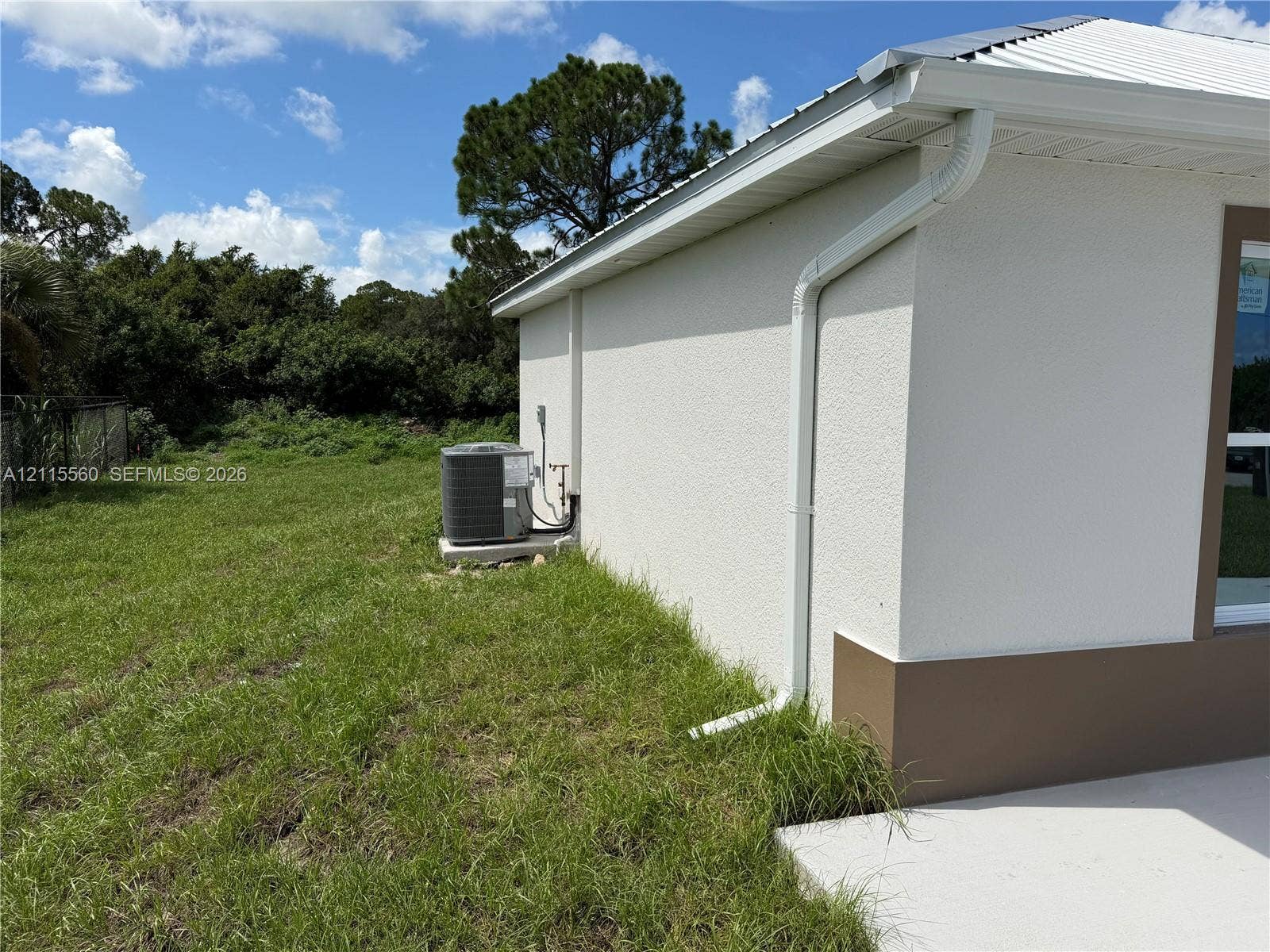 105 Concord Loop, Labelle, FL 33935 Stucco exterior siding, metal roof, and concrete side patio