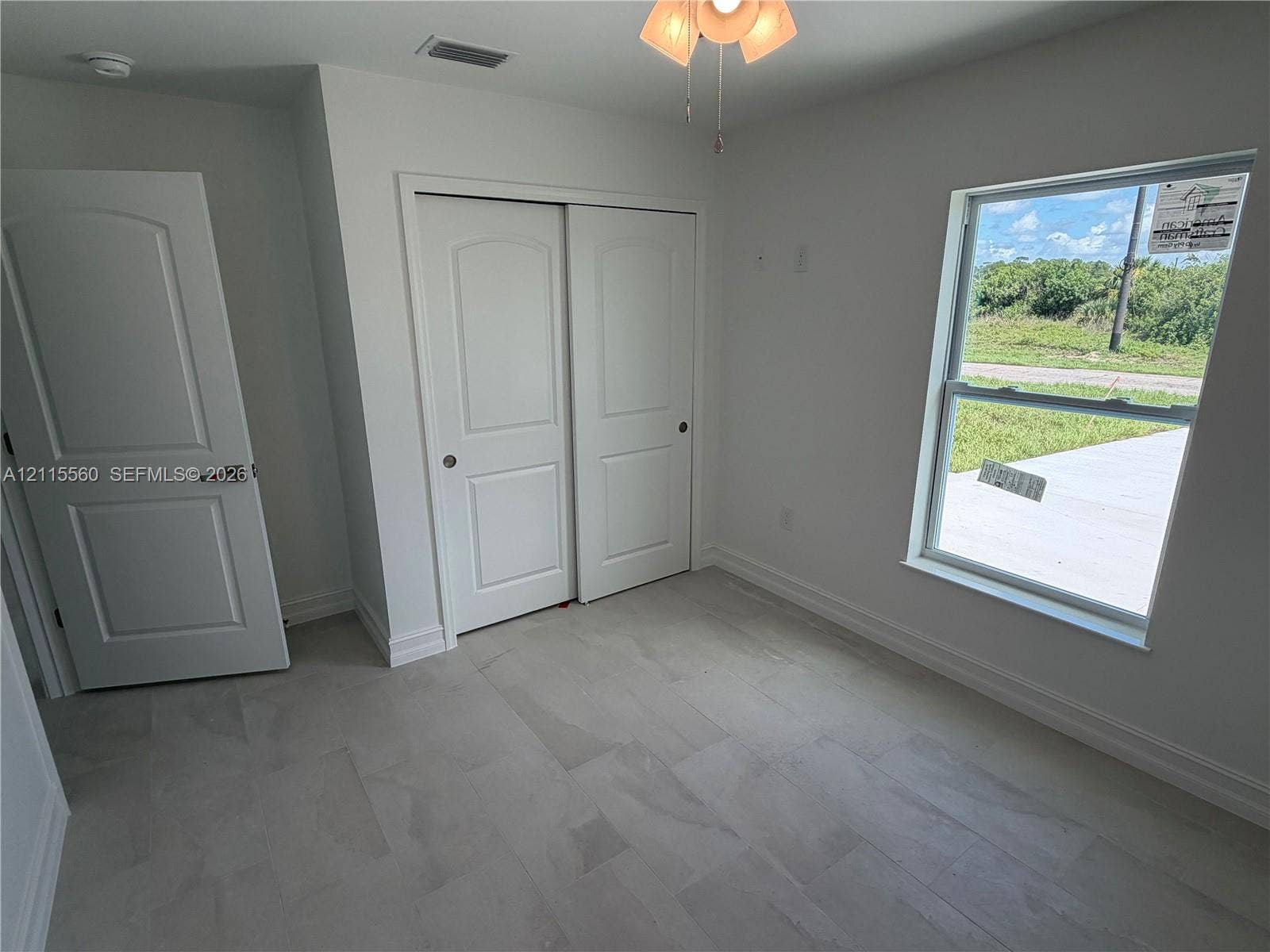 105 Concord Loop, Labelle, FL 33935 Neutral-toned tile flooring, two-panel interior doors, double-door reach-in closet, and single-hung window