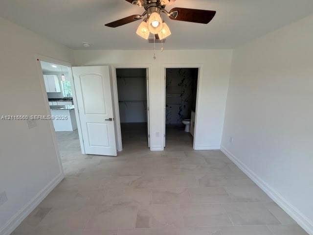 105 Concord Loop, Labelle, FL 33935 Neutral wall finish with tile flooring, three-panel interior door, and ceiling fan with integrated light fixture