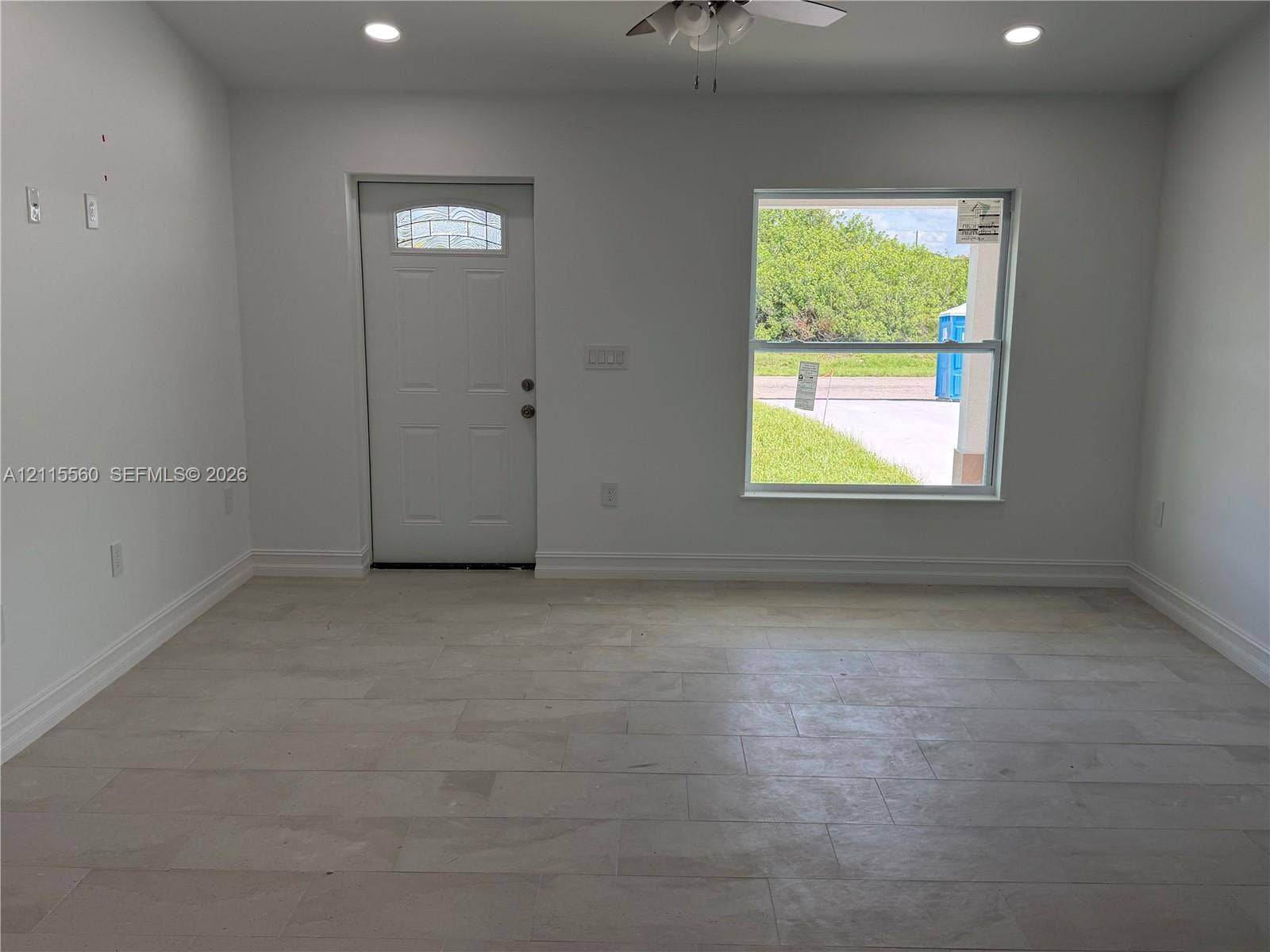 105 Concord Loop, Labelle, FL 33935 Neutral-toned tile flooring, recessed ceiling lighting, ceiling fan, and white entry door with a decorative glass insert