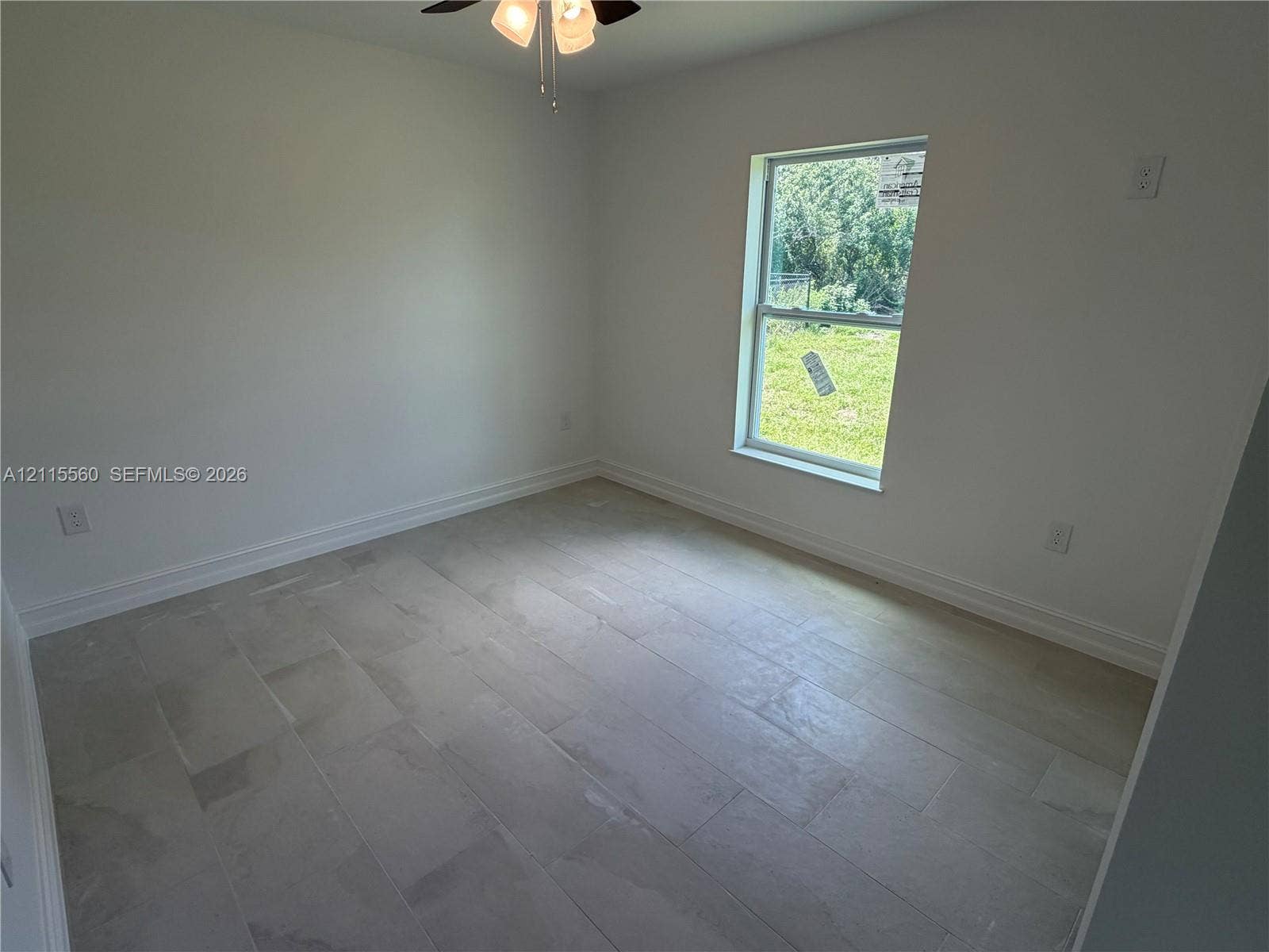 105 Concord Loop, Labelle, FL 33935 Neutral interior space featuring large-format tile flooring, a single-hung window, and a ceiling-mounted light fixture