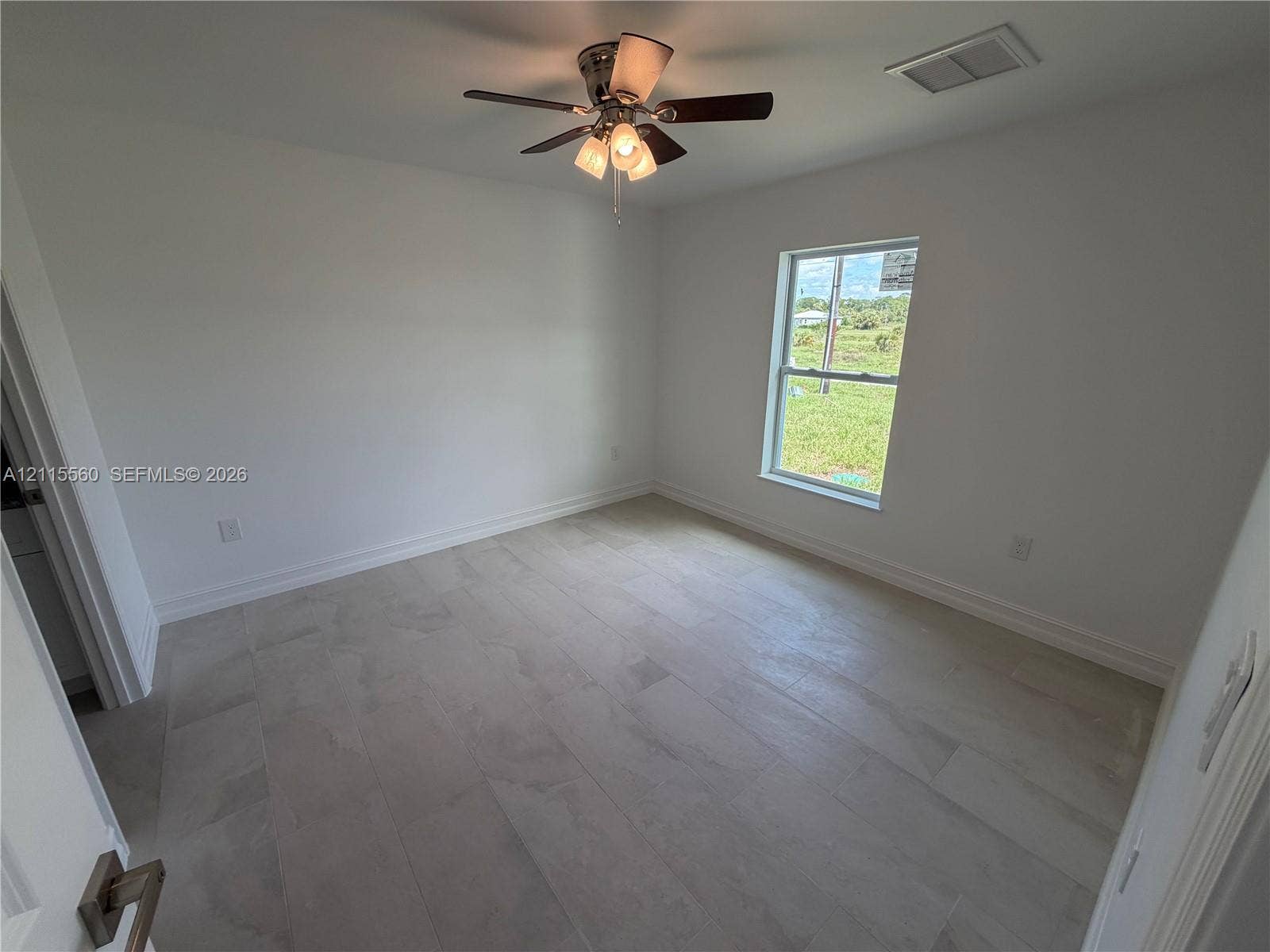 105 Concord Loop, Labelle, FL 33935 Interior room featuring neutral wall finishes, large-format tile flooring, a multi-light ceiling fan, and a window with exterior exposure