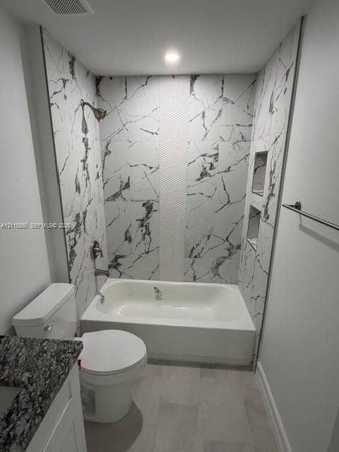 105 Concord Loop, Labelle, FL 33935 Bathtub surround featuring large-format stone-patterned tile, a vertical textured accent inlay, dual built-in recessed wall niches, and a polished metal shower fixture