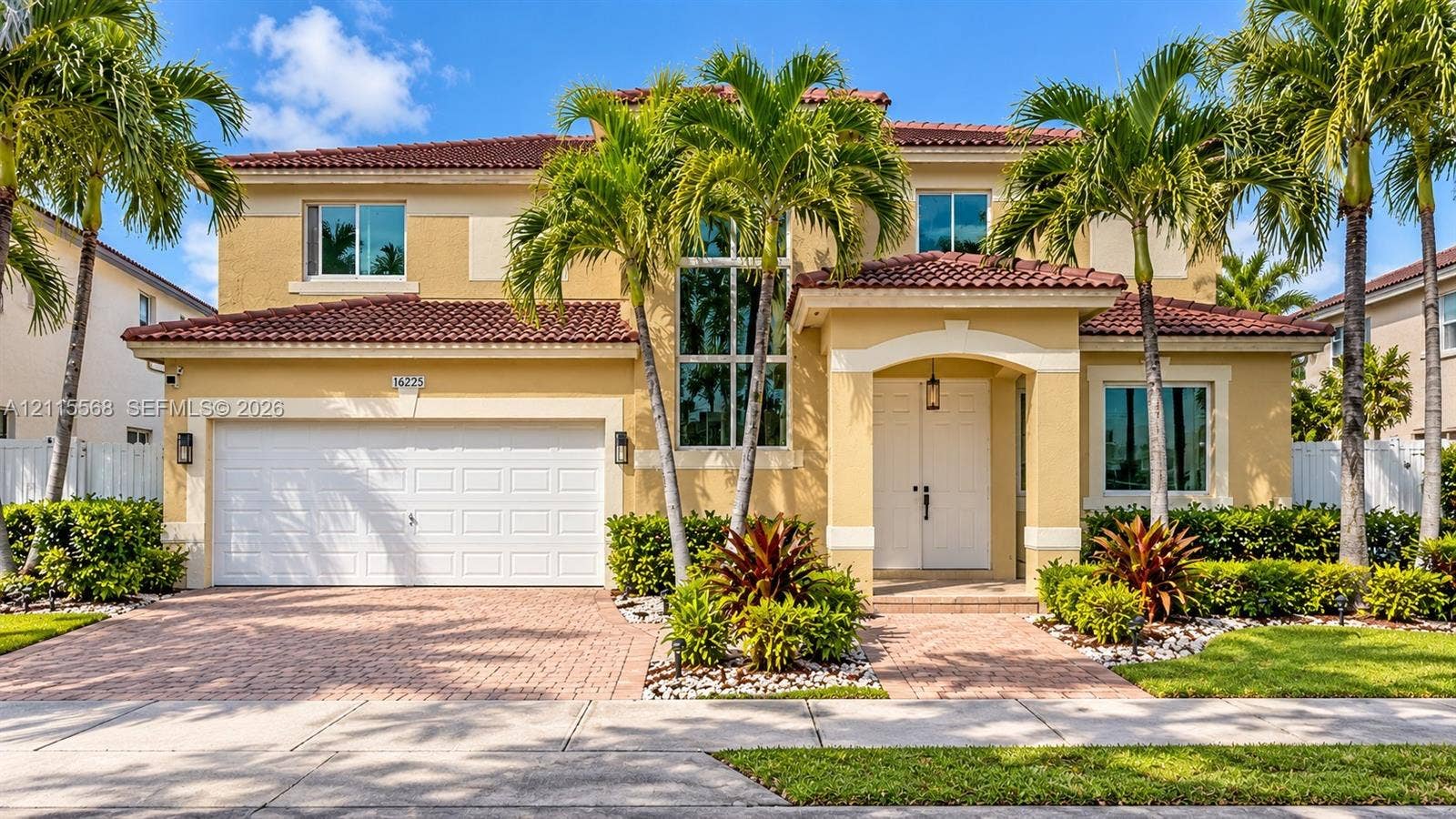 16225 SW 61st Lane, Miami, FL 33193 Two-story residence featuring a tile roof, stucco exterior, paver driveway, double-door entryway, and floor-to-ceiling accent windows