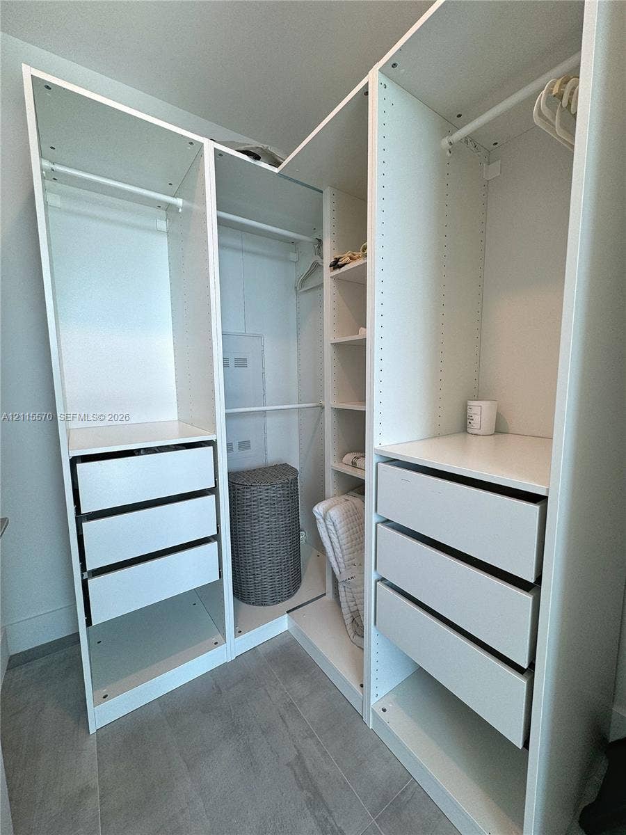 17550 Collins Avenue, #1401, Sunny Isles Beach, Sunny Isles Beach, FL 33160 Custom reach-in closet featuring white modular cabinetry, integrated shelving, tiered drawer storage, and hanging rods