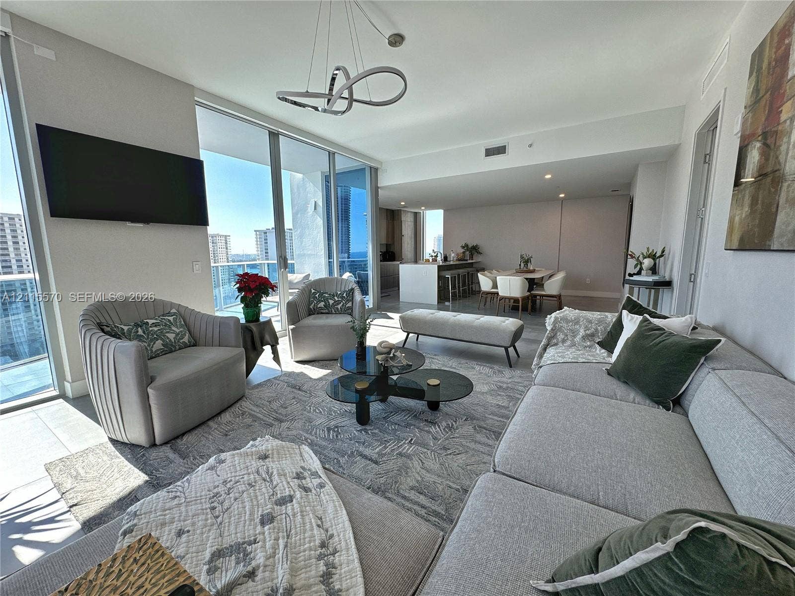 17550 Collins Avenue, #1401, Sunny Isles Beach, Sunny Isles Beach, FL 33160 Open-concept living area featuring floor-to-ceiling glass sliding doors, recessed lighting, modern geometric chandelier, and tile flooring