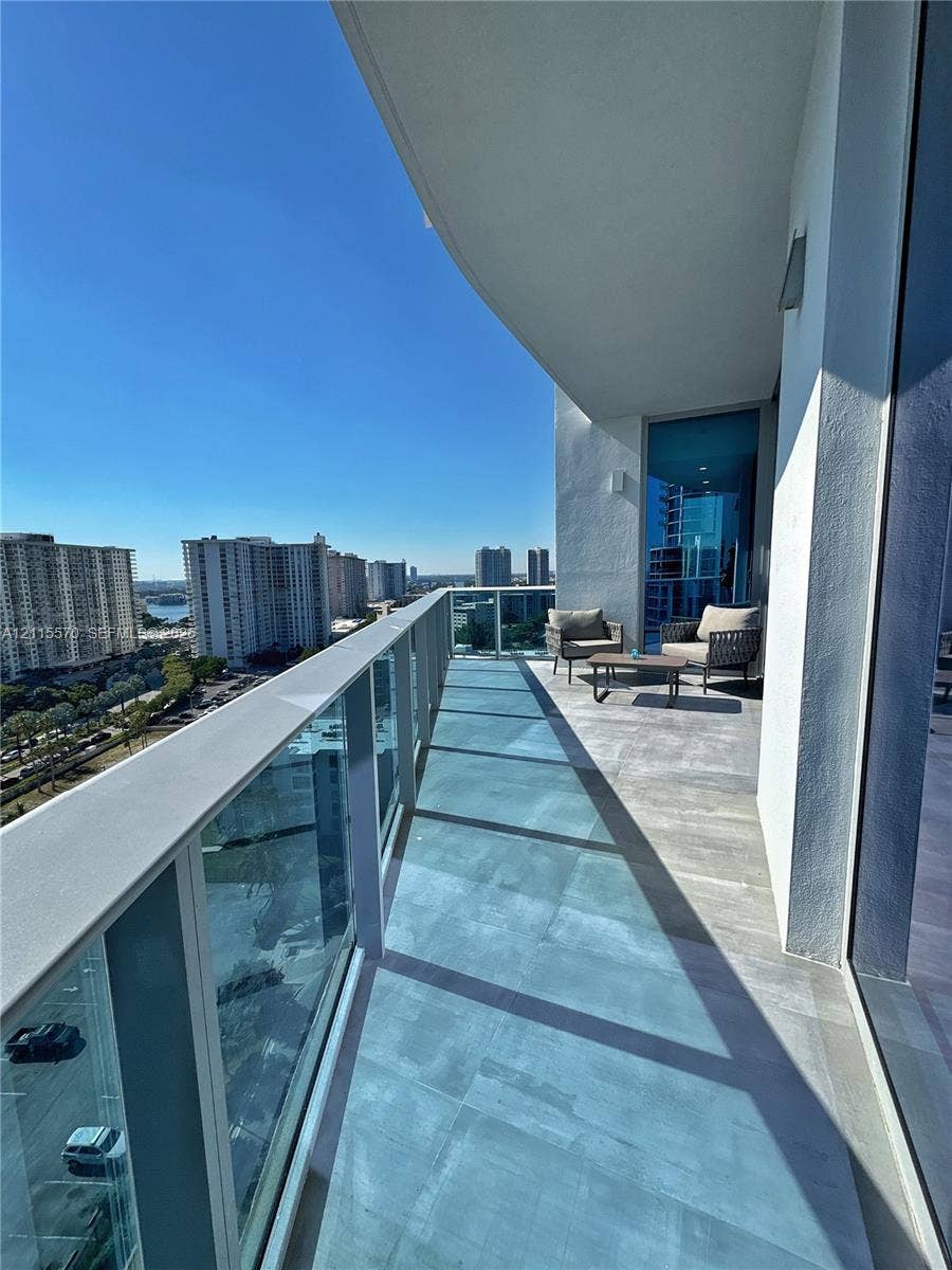 17550 Collins Avenue, #1401, Sunny Isles Beach, Sunny Isles Beach, FL 33160 Covered private balcony featuring large-format ceramic tile flooring and a glass panel railing