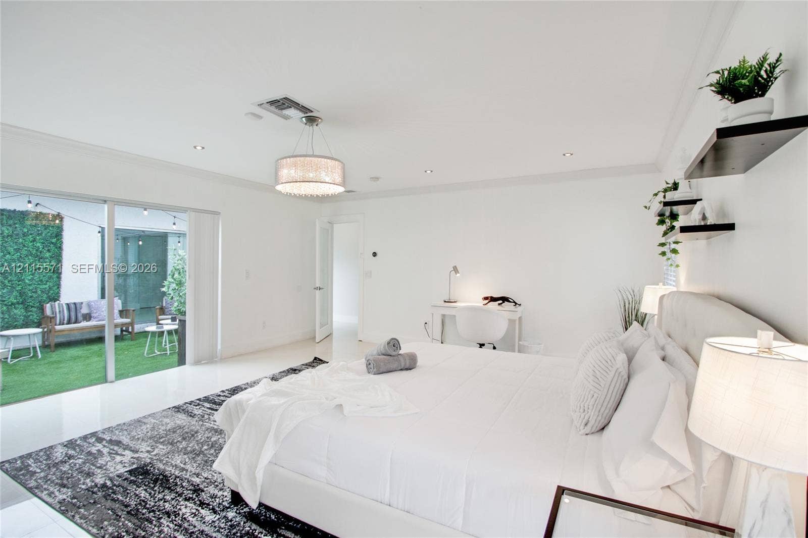 2001 NE 122nd Road, North Miami, FL 33181 Large room featuring polished stone flooring, recessed lighting, a decorative drum pendant light, sliding glass doors, and built-in floating wall shelving