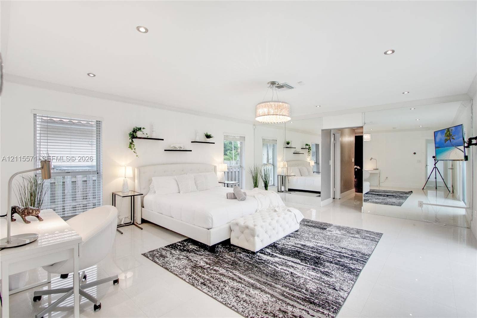 2001 NE 122nd Road, North Miami, FL 33181 Spacious room featuring polished tile flooring, recessed lighting, a decorative chandelier, and mirrored wall panels